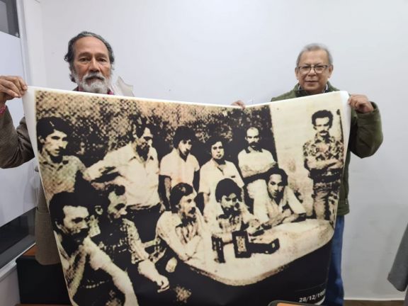 Velázquez y Pelito Escobar sostienen un mural con la imagen de varios presos políticos.