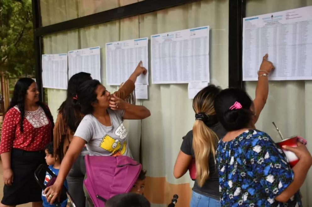Mujeres revisando el padrón en el acceso a la escuela del barrio Los Paraísos de Posadas