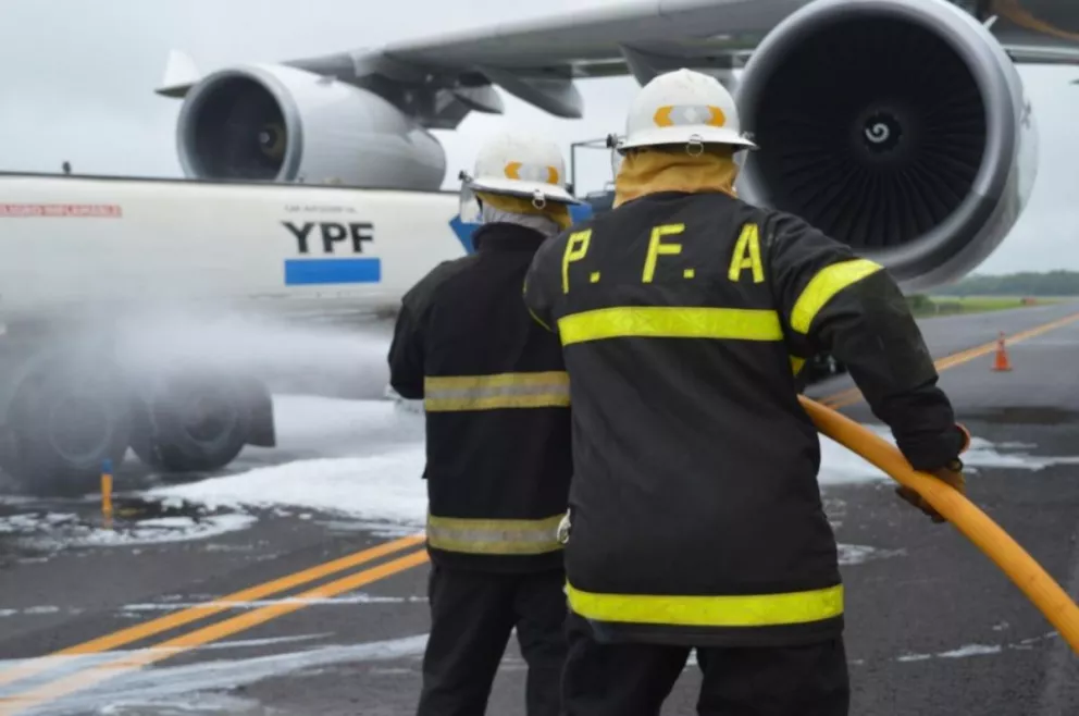 Bomberos simulan combatir un incendio en una aeronave que carga combustible