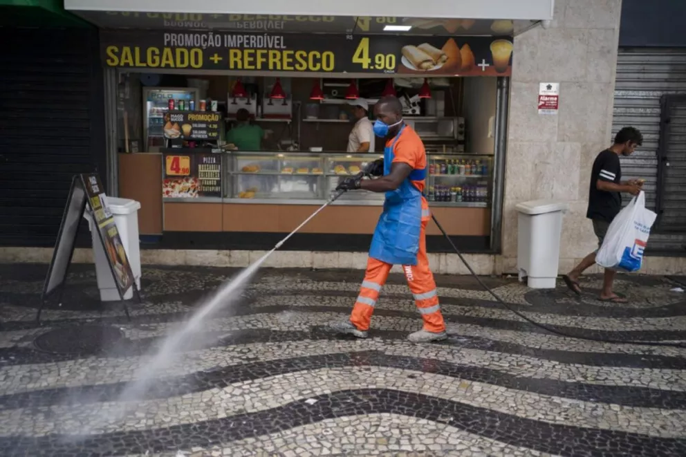 Brasil. Un empleado municipal limpia y desinfecta las veredas de Río de Janeiro