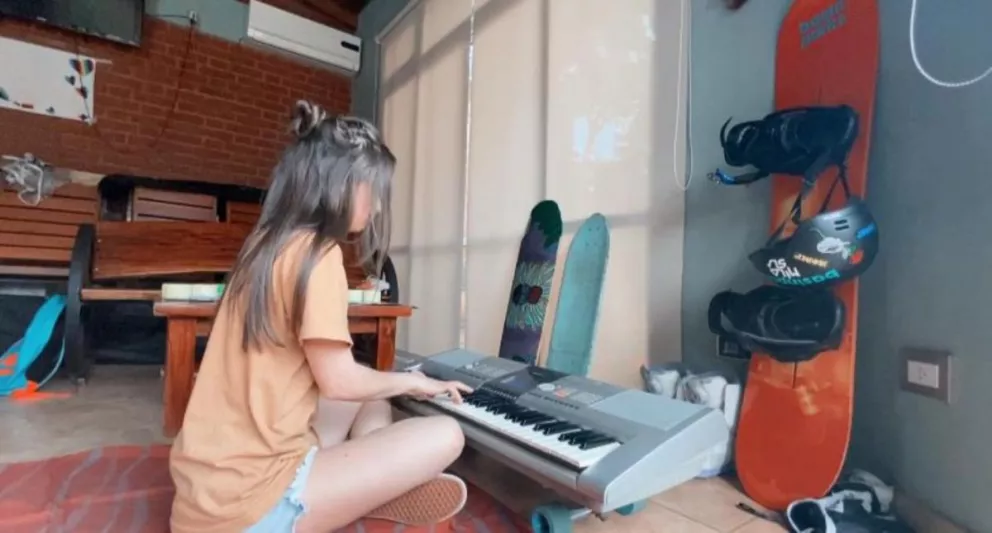 Antonella Olivera practicando con su teclado en el quincho familiar
