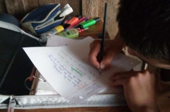 Un niño de San Pedro haciendo su tarea Un niño de San Pedro haciendo su tarea