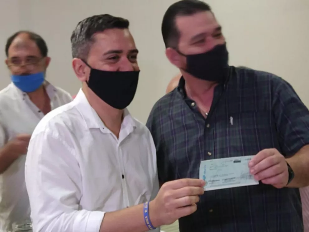 El minsitro de Turismo, José María Arrúa, entrega a uno de los beneficiarios los fondos de ayuda
