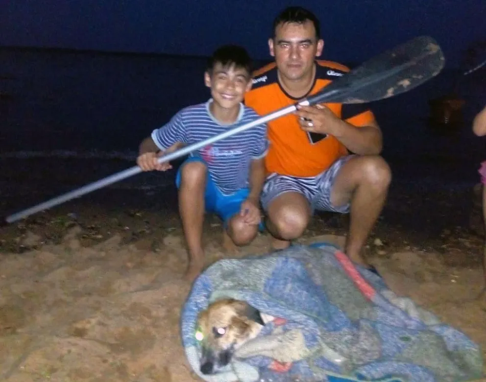 Padre e hijo rescatan a un perro del río, en plena tormenta